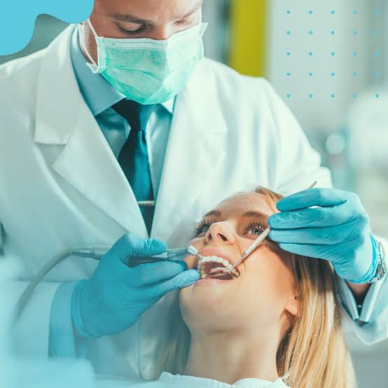 Cirurgião-dentista atendendo paciente em consultório odontológico